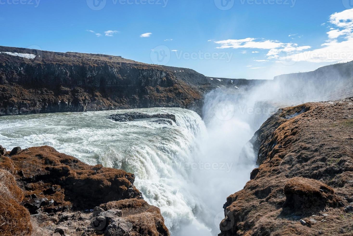 Powerful cascades of Gullfoss waterfall in scenic Golden Circle against blue sky photo