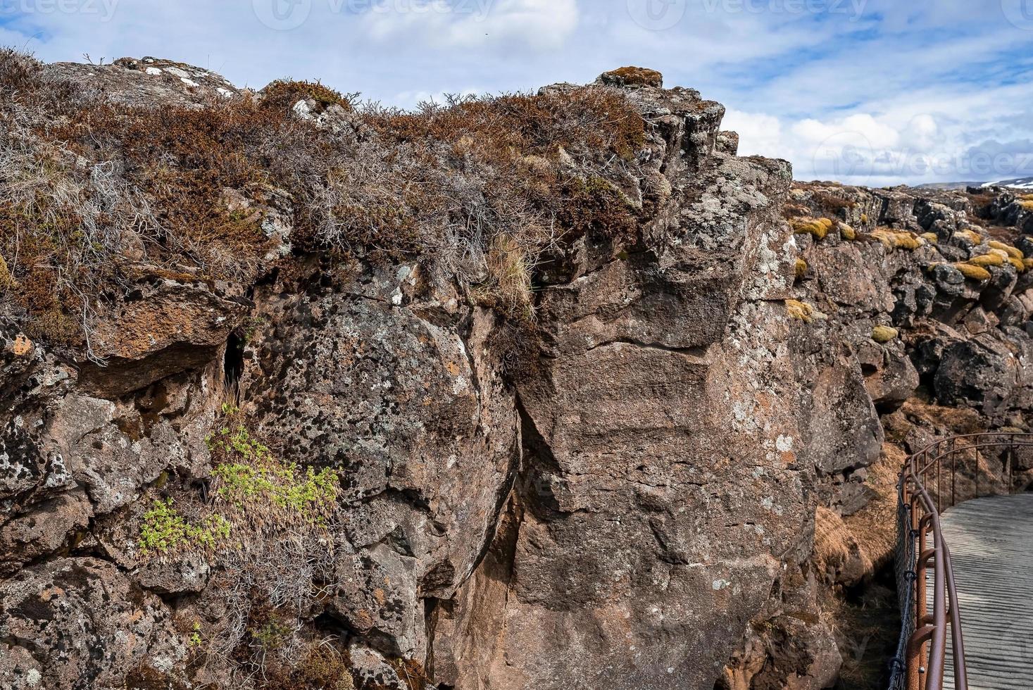 puente metálico por majestuosa formación rocosa en el parque nacional de Thingvellir foto