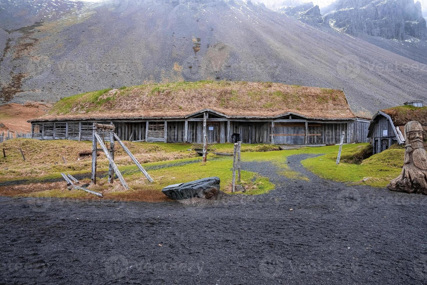 Abandoned traditional houses in Viking village against Vestrahorn mountain photo