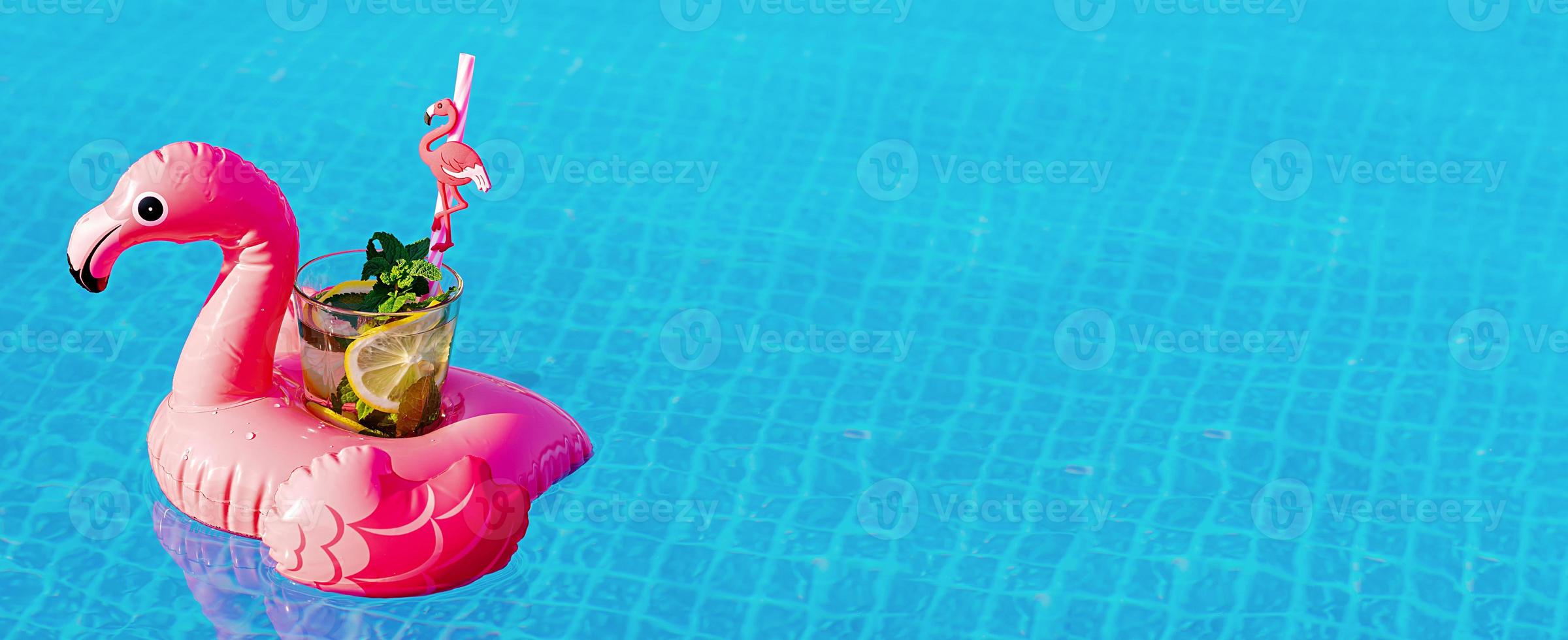 mojito de cóctel fresco en un juguete inflable de flamenco rosa en la piscina. concepto de vacaciones. foto