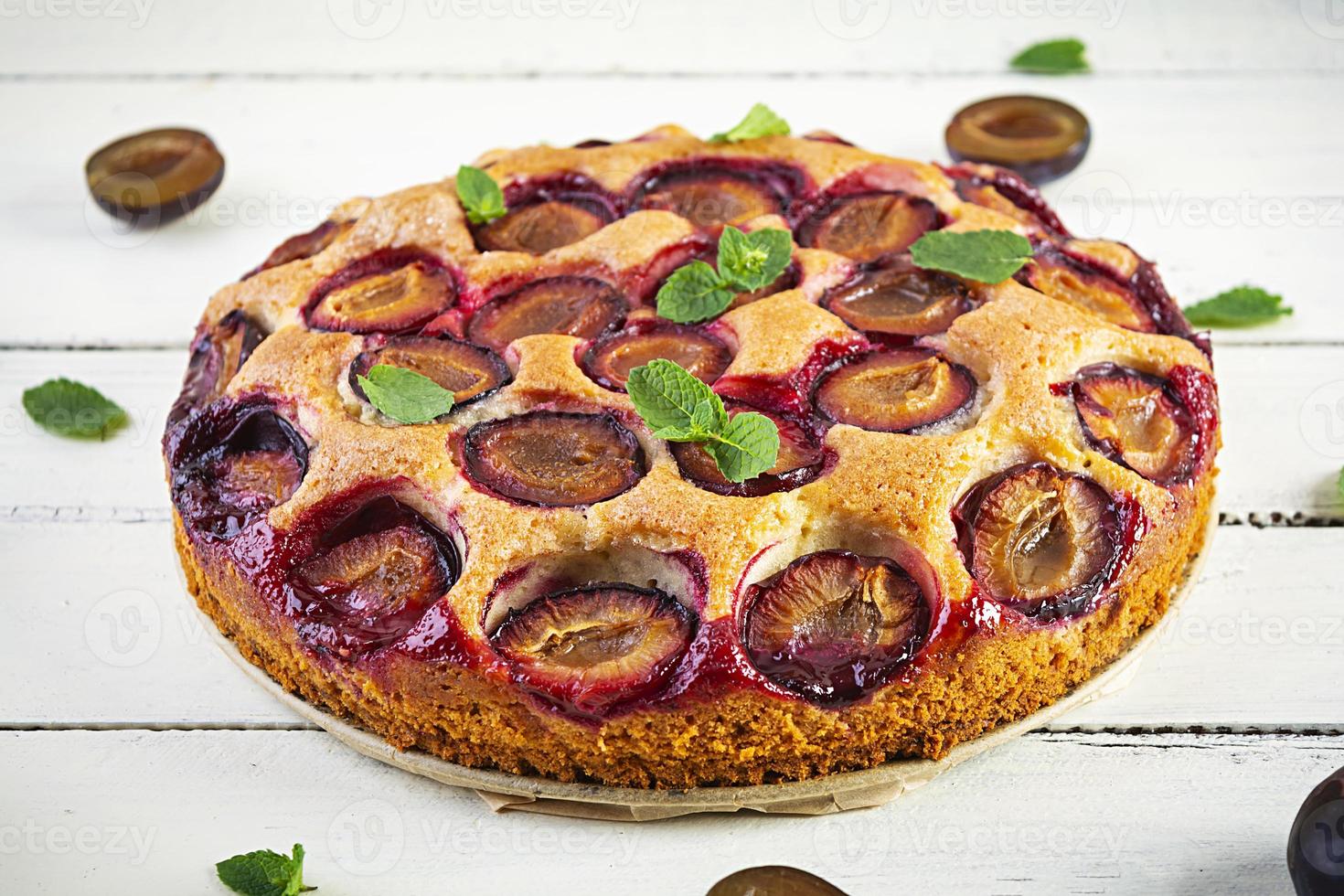 Delicious homemade plum pie on white background photo