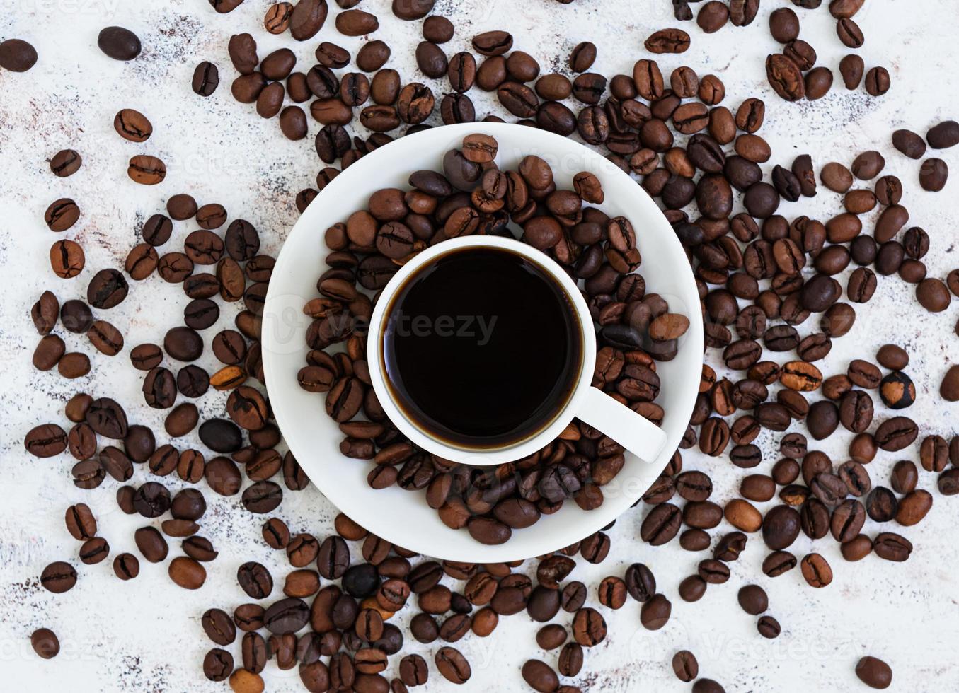 Coffee cup and coffee beans on white background. Top view. Flat lay photo
