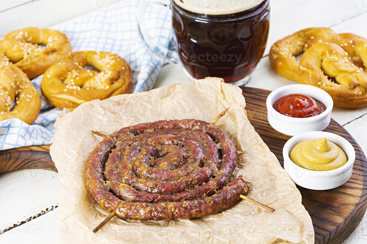 Food menu for Oktoberfest. Sausage with different sauce, pretzel and glass of dark beer photo