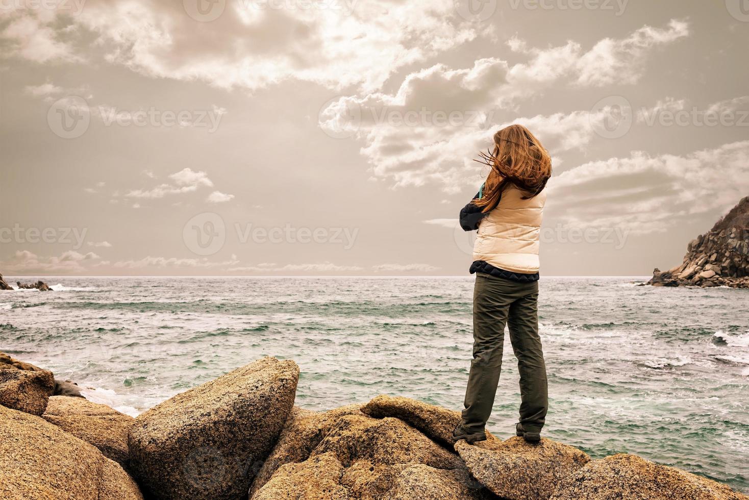 girl standing on a rock photo