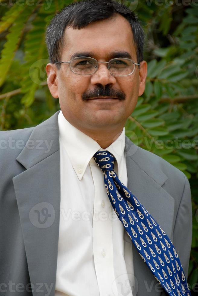 An Indian businessman wearing spectacles and in a light blue suit photo