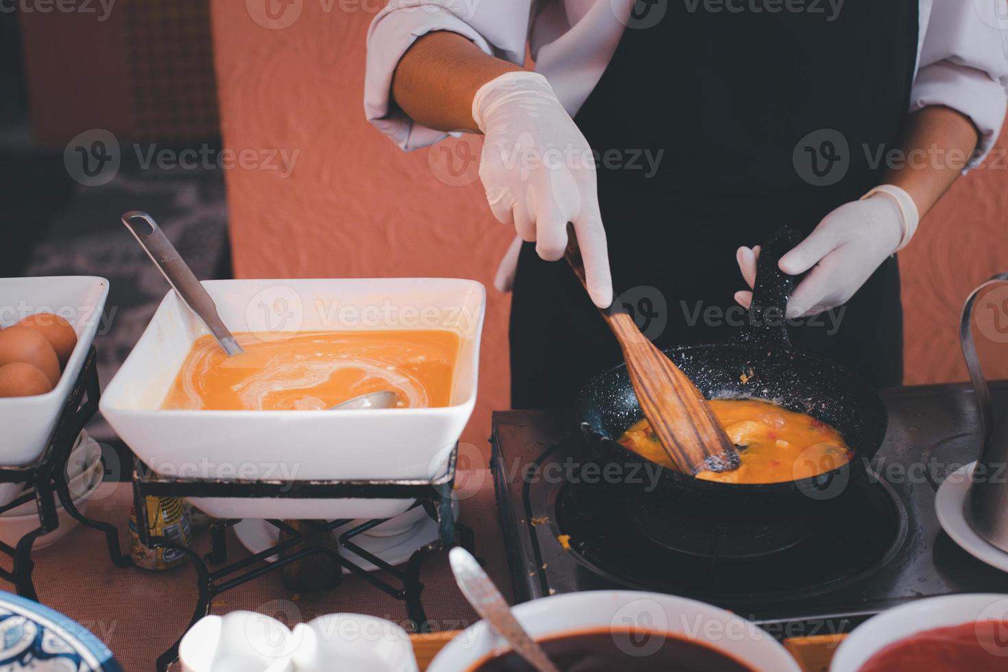 Chef is making breakfast omelettes with eggs, ketchup and chili sauce as a garnish. photo