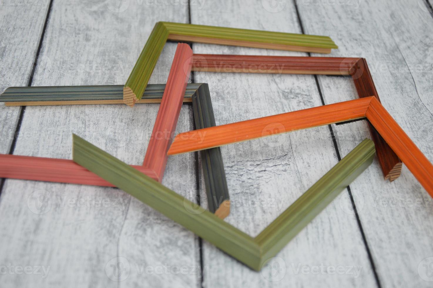 Decorative modern colored picture frames. Patterns of frames for a baguette, lying on a wooden background. Workshop photo