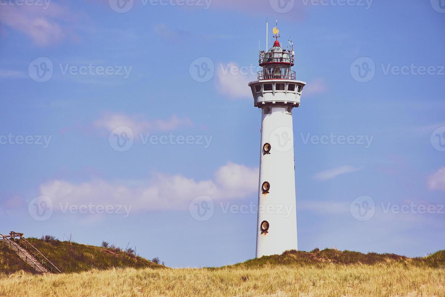 lighthouse of Egmond aan Zee in the Netherlands against blue sky with white big cloud photo