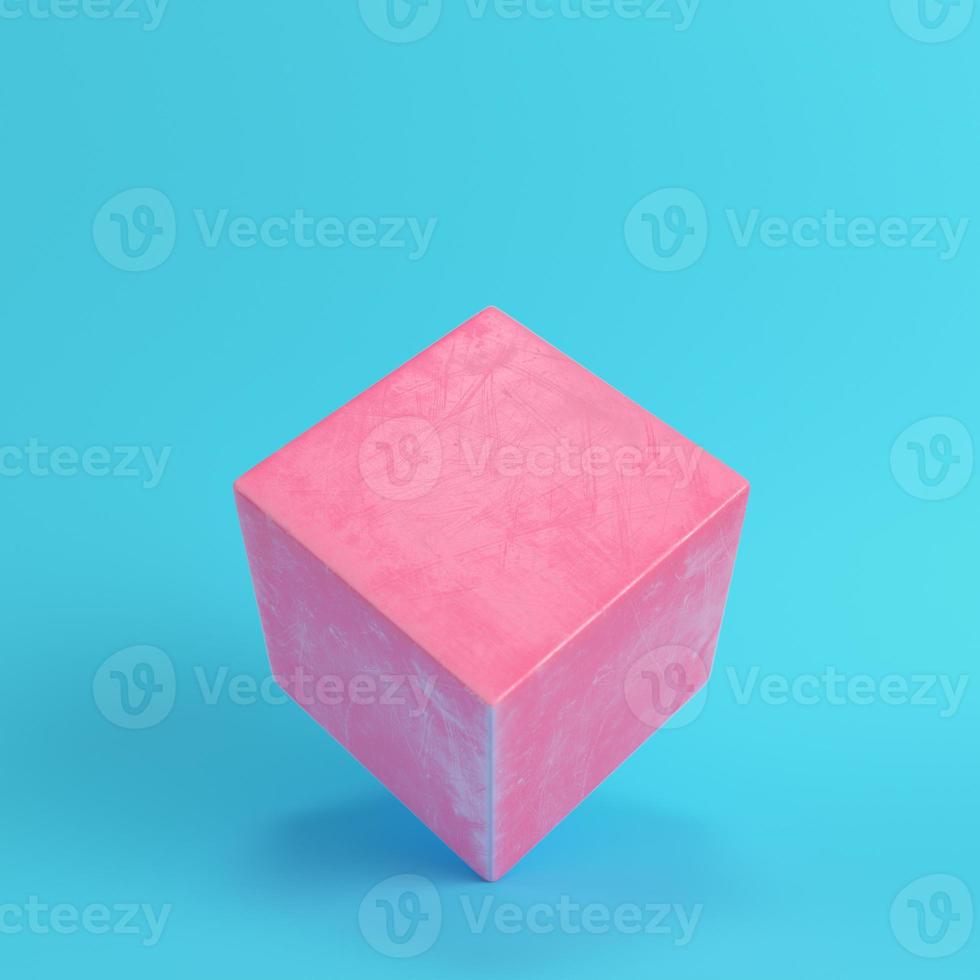 Abstract pink cube with scratches on bright blue background in pastel colors photo