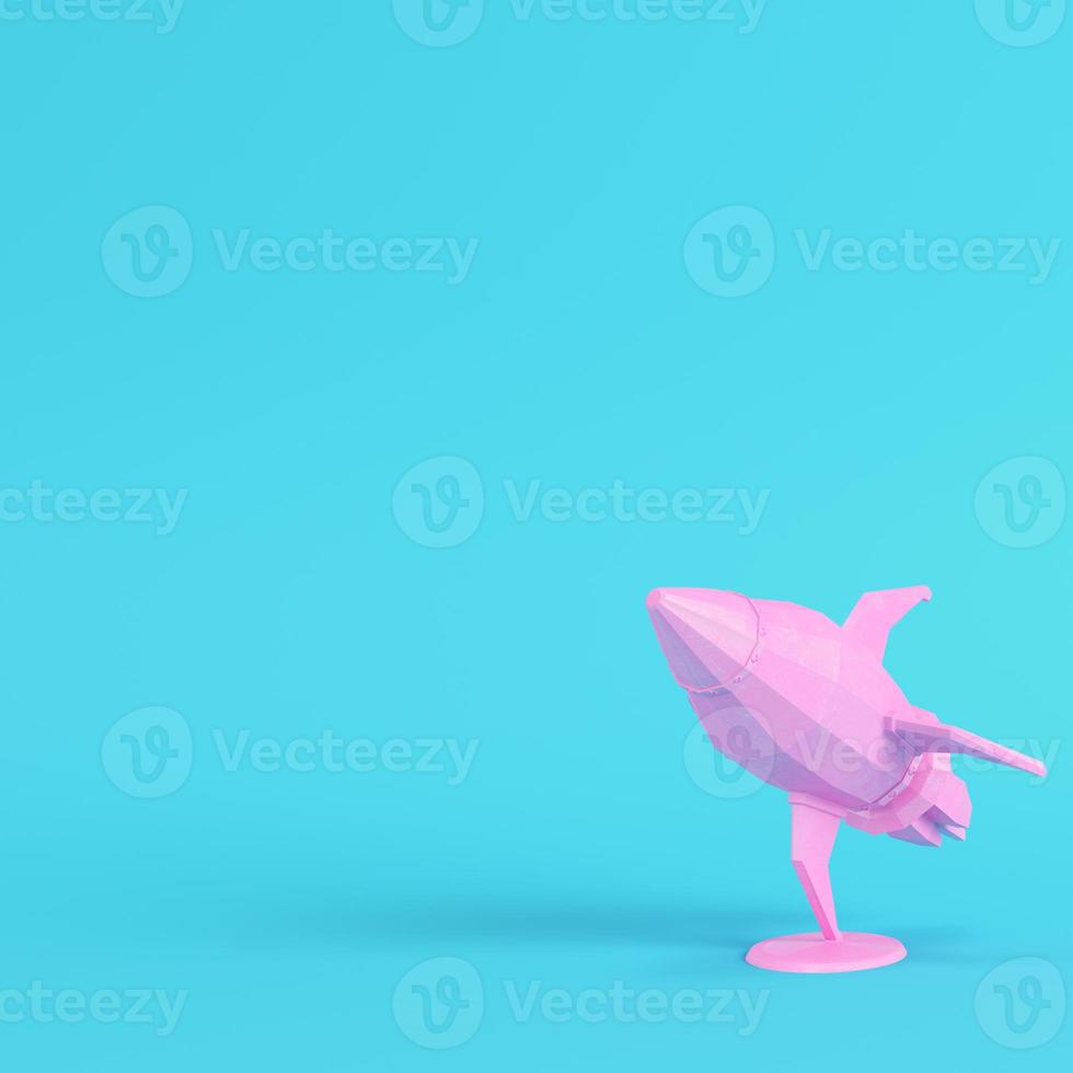 Pink rocket with stand on bright blue background in pastel colors. Minimalism concept photo