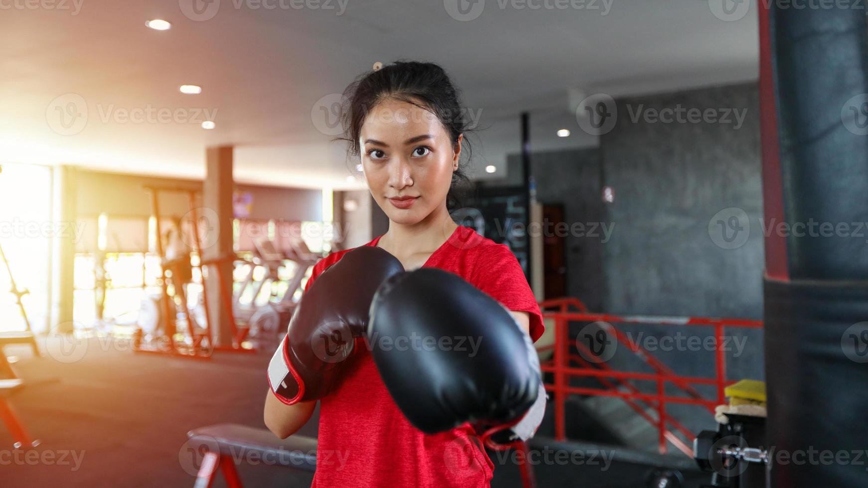 Beautiful women Asian boxer happy and fun fitness boxing and Punching A Bag With wearing boxing gloves. photo