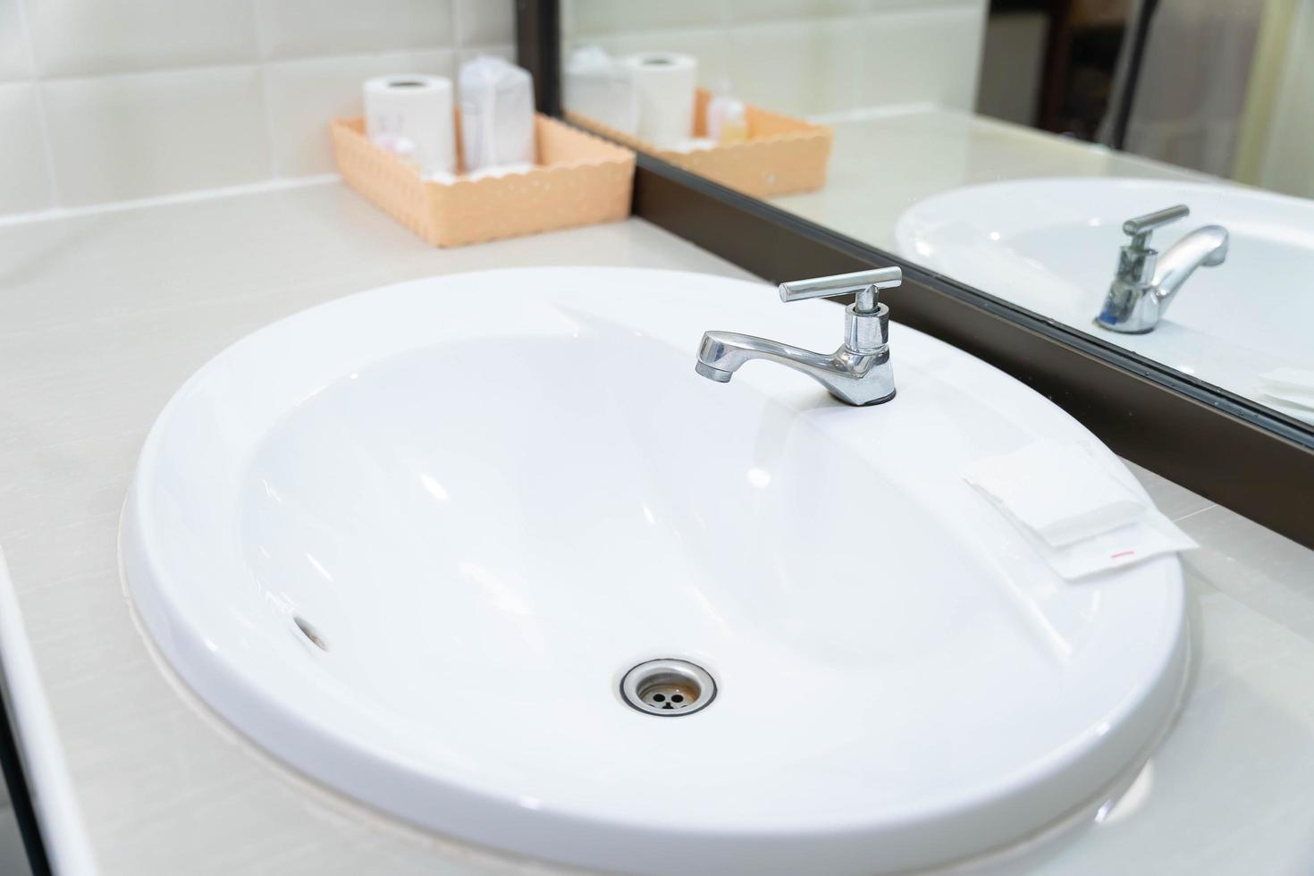 The Water faucet stainless and white sinks of a hotel bathroom are new and clean. besides, there is a soap for handwashing photo