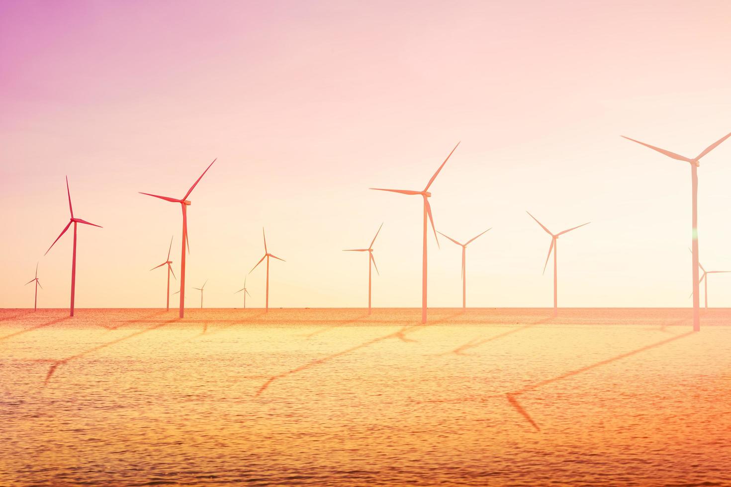 Wind turbines farm on the sea is an alternative electricity source, Concept of sustainable resources, Sunlight in summer with wind generators turbines, Renewable energy concept photo