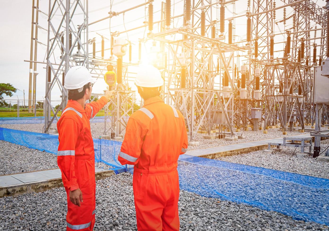 los ingenieros eléctricos usaron un termómetro para verificar fallas en los conjuntos de equipos, también conocido como mantenimiento preventivo para reducir el daño del equipo, concepto de ingeniero profesional en la industria foto