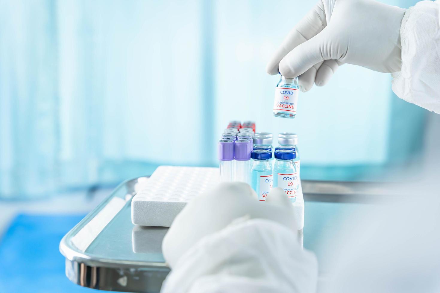 close up a vaccine bottle in the hand of a doctor from the scientific laboratory, a concept of drug use to treat and protect the global COVID-19 pandemic photo