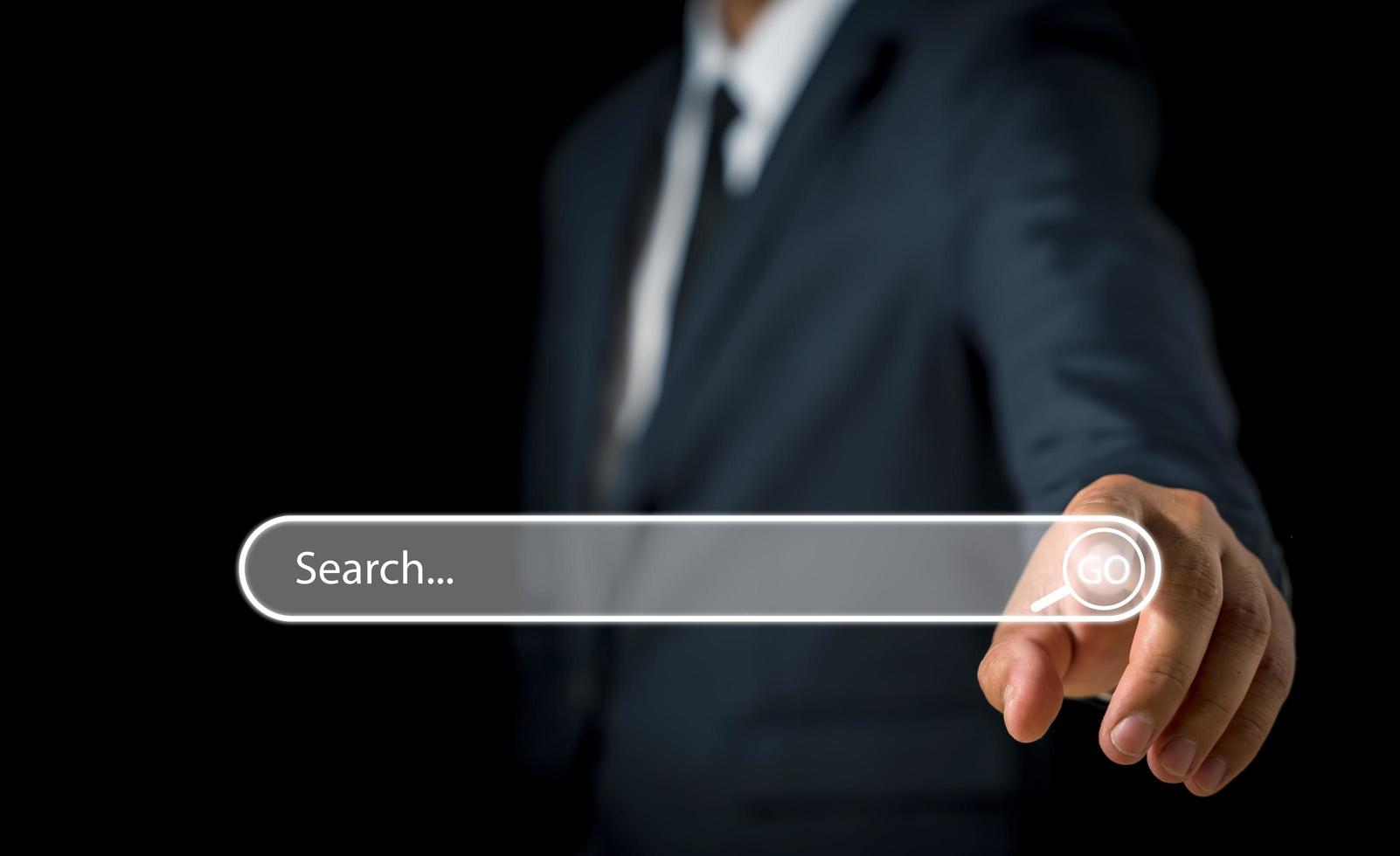 Businessman hand pressing blank search bar on a virtual online computer or screen to Searching for information. photo