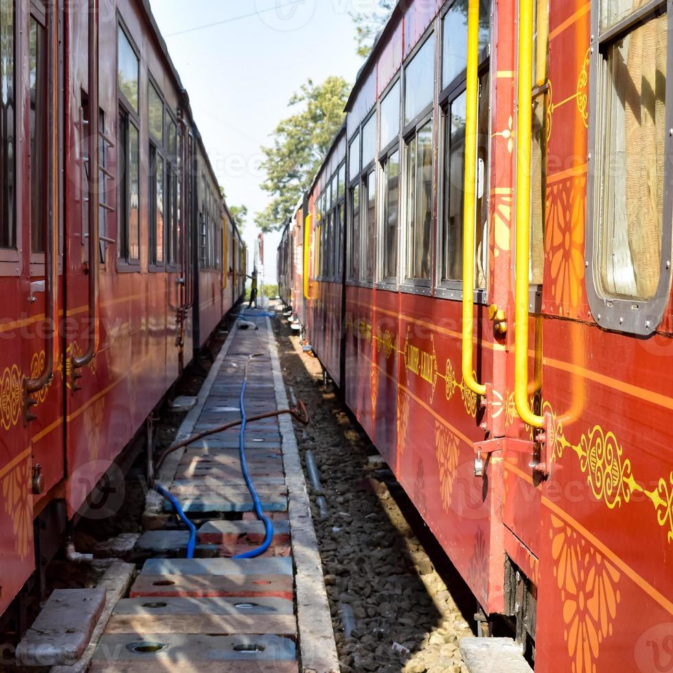 Toy Train moving on mountain slopes, beautiful view, one side mountain, one side valley moving on railway to the hill, among green natural forest. Toy train from Kalka to Shimla in India photo