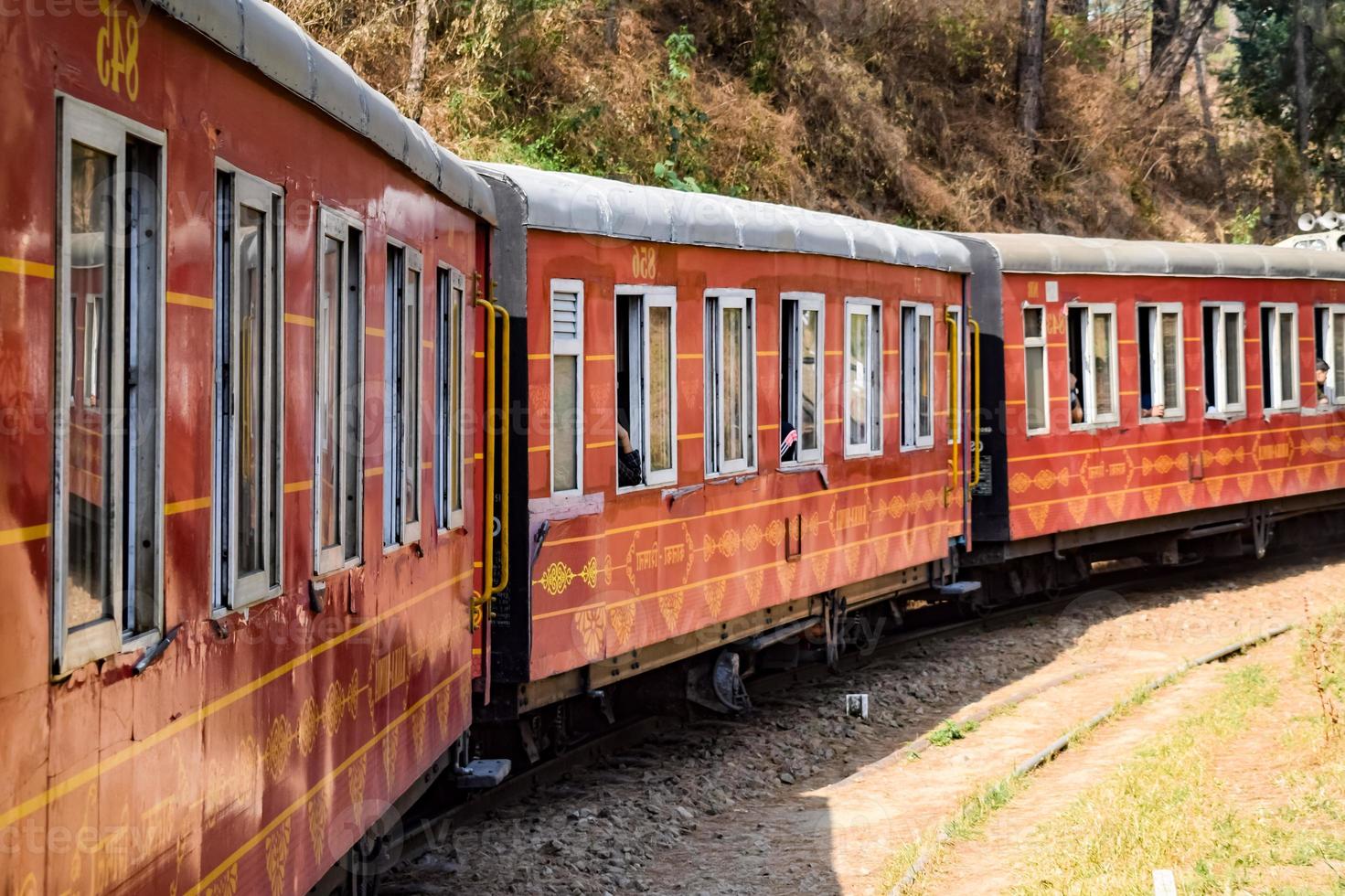 Toy Train moving on mountain slopes, beautiful view, one side mountain, one side valley moving on railway to the hill, among green natural forest. Toy train from Kalka to Shimla in India photo