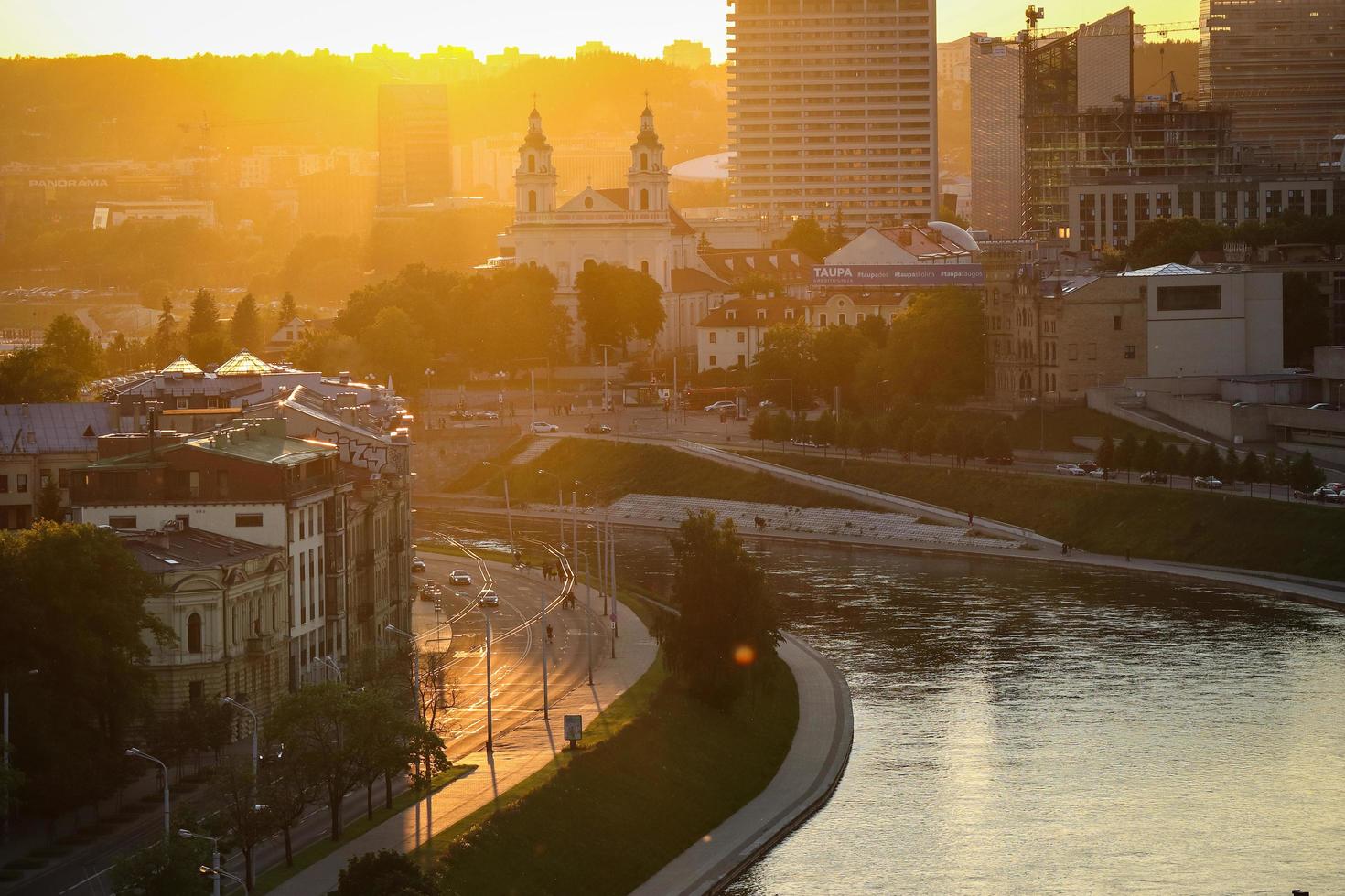 Vilnius, Lithuania. June 06 2022 - Aerial top view on lively street buildings and river from Gediminas palace in sunset photo