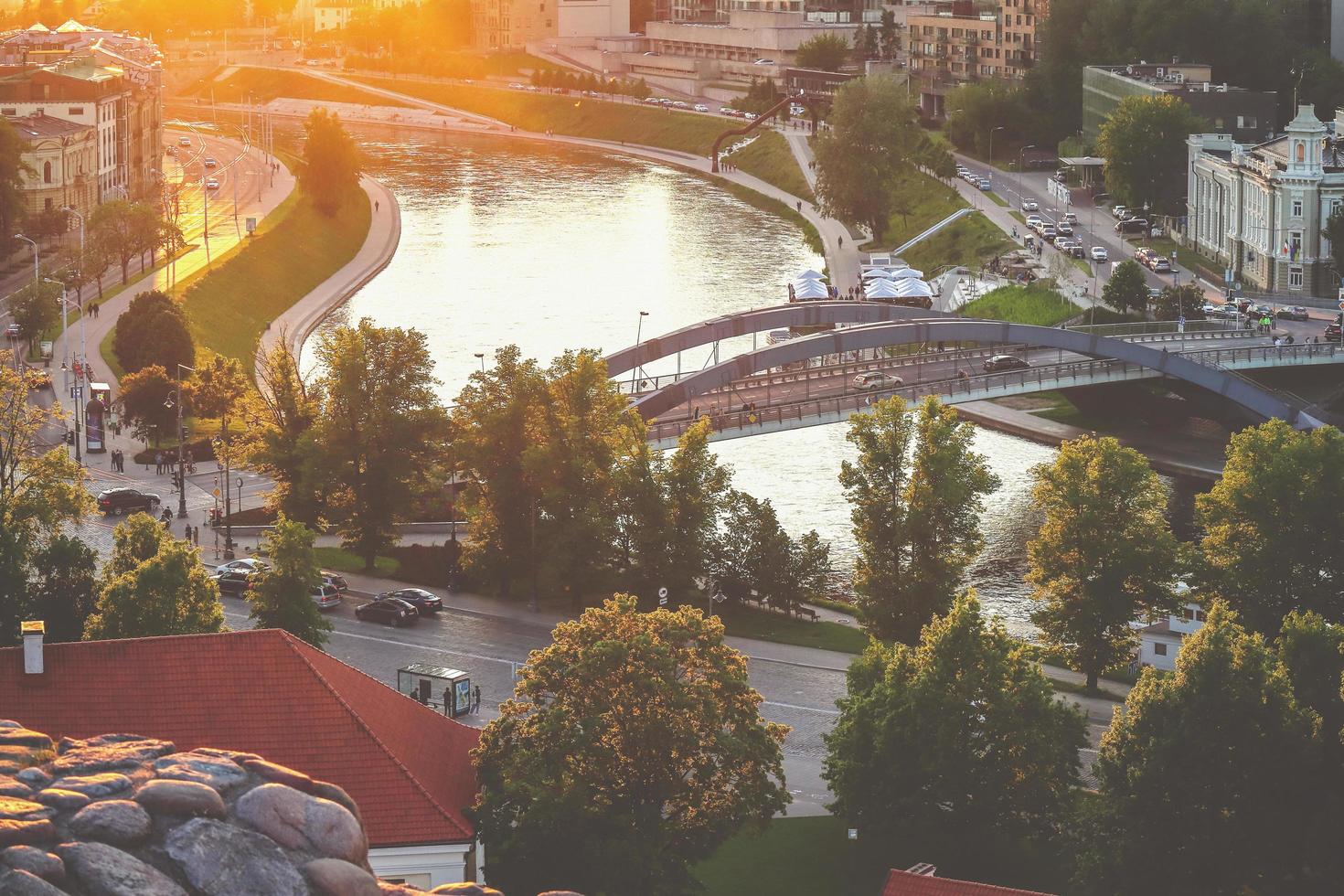 Aerial top view on lively street buildings, bridge and river from Gediminas palace in sunset photo
