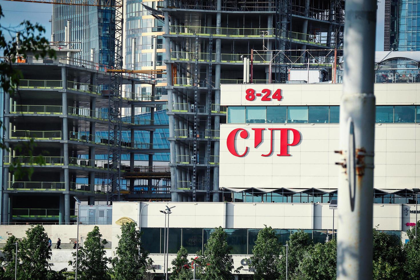 Vilnius city shop center CUP and other buildings under construction process on background on summer day photo