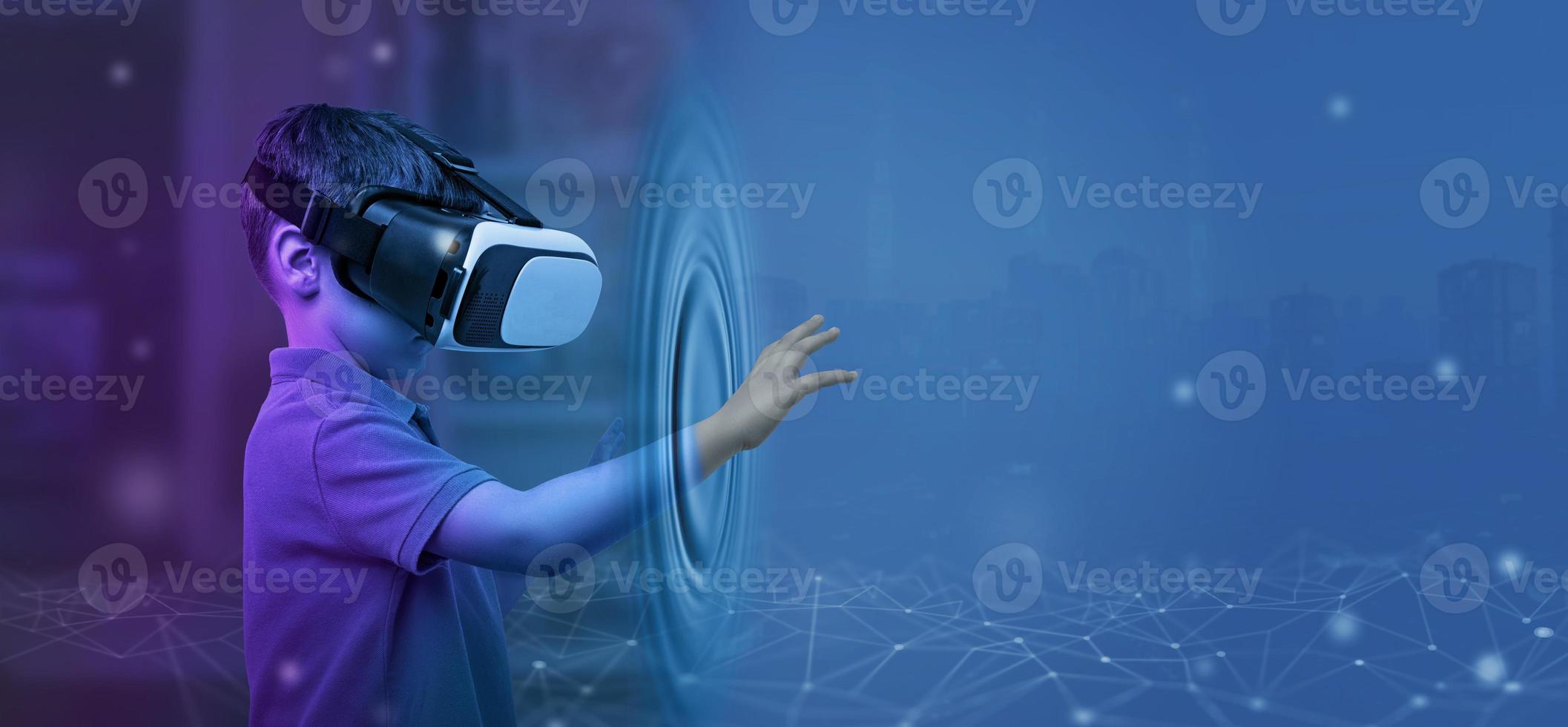 Boy with VR glasses from his room touches the metaverse with his hand. Copy space on blue background photo