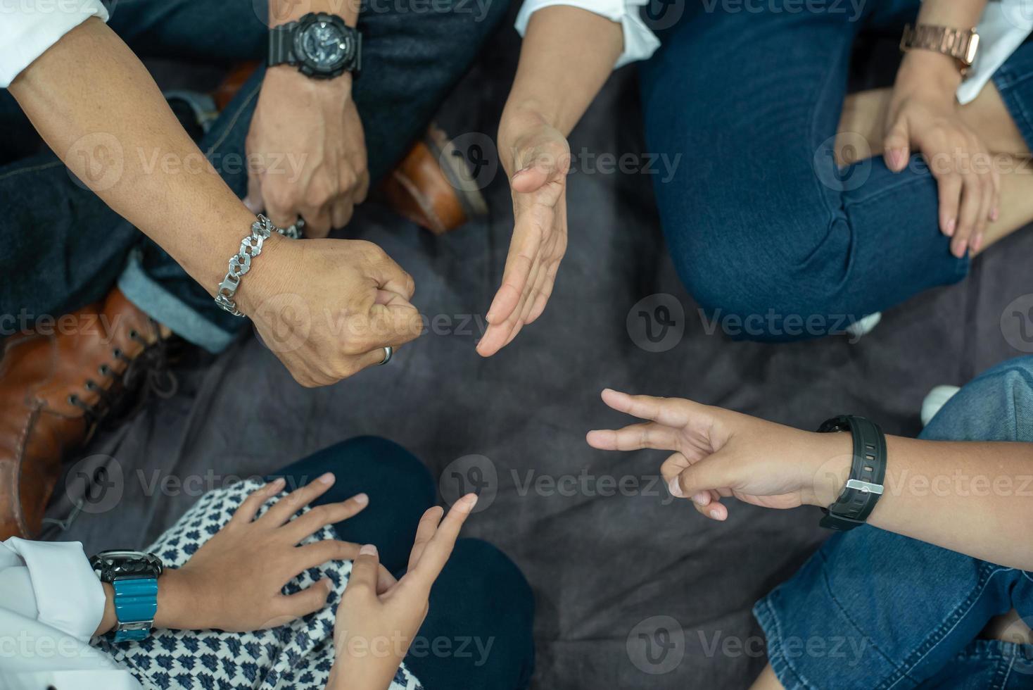 The hands of one family blew the rock paper scissors. There are both the hands of adults and children. photo