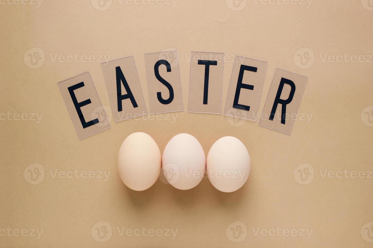 Easter eggs on pastel brown background with lettering. Top view. Flat lay. Minimal concept photo