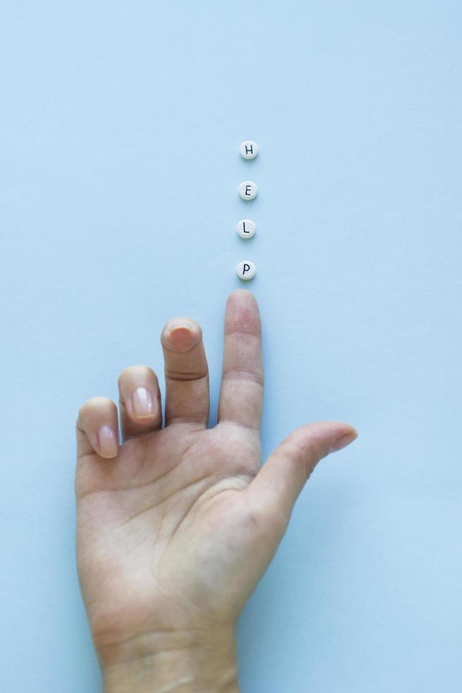 Female hand and tablets with inscription HELP on blue background. Healthcare and medical concept with copy space. Top view. Minimalism photo