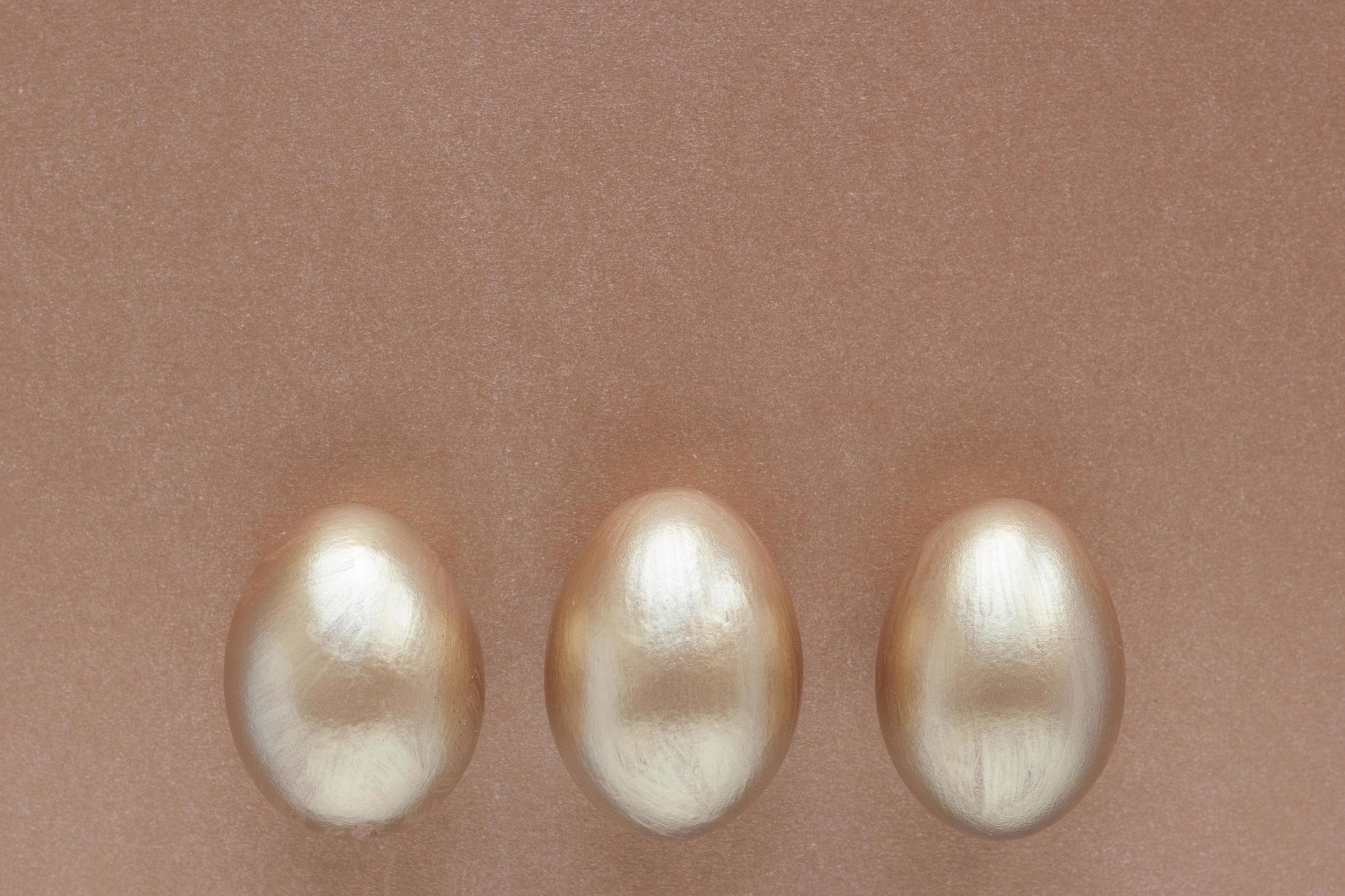Golden eggs with copy space for text on bronze background. Top view