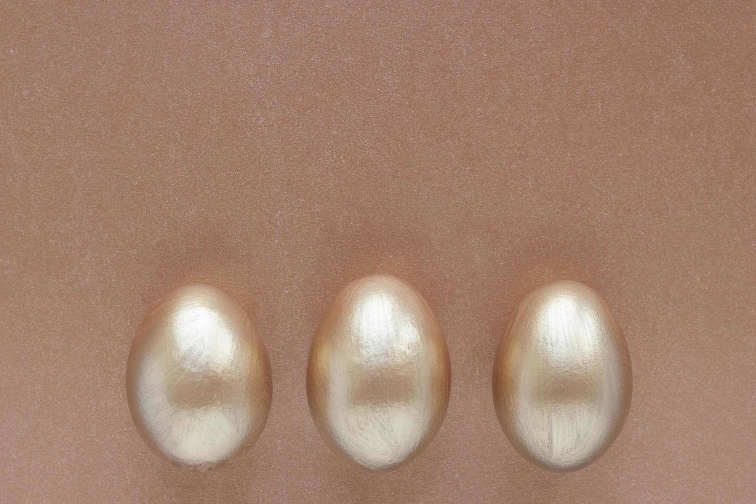 Golden eggs with copy space for text on bronze background. Top view concept with bronze eggs in flat lay style. Idea for greetings and Easter photo