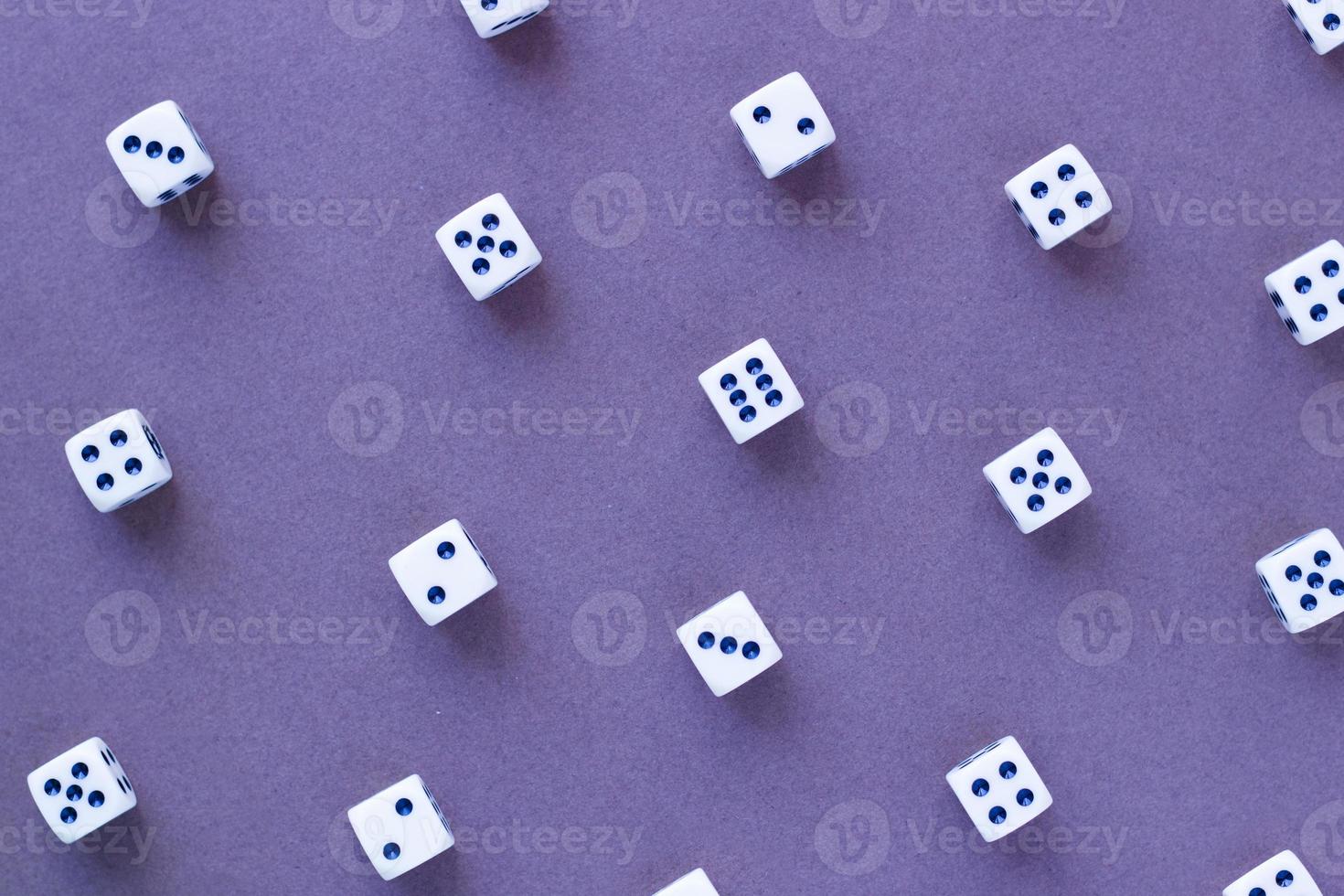 Gaming white dice pattern on purple background in flat lay style. Concept with copy space for games, game board, role playing game, risk, chance, good luck or gambling. Toned image top view photo