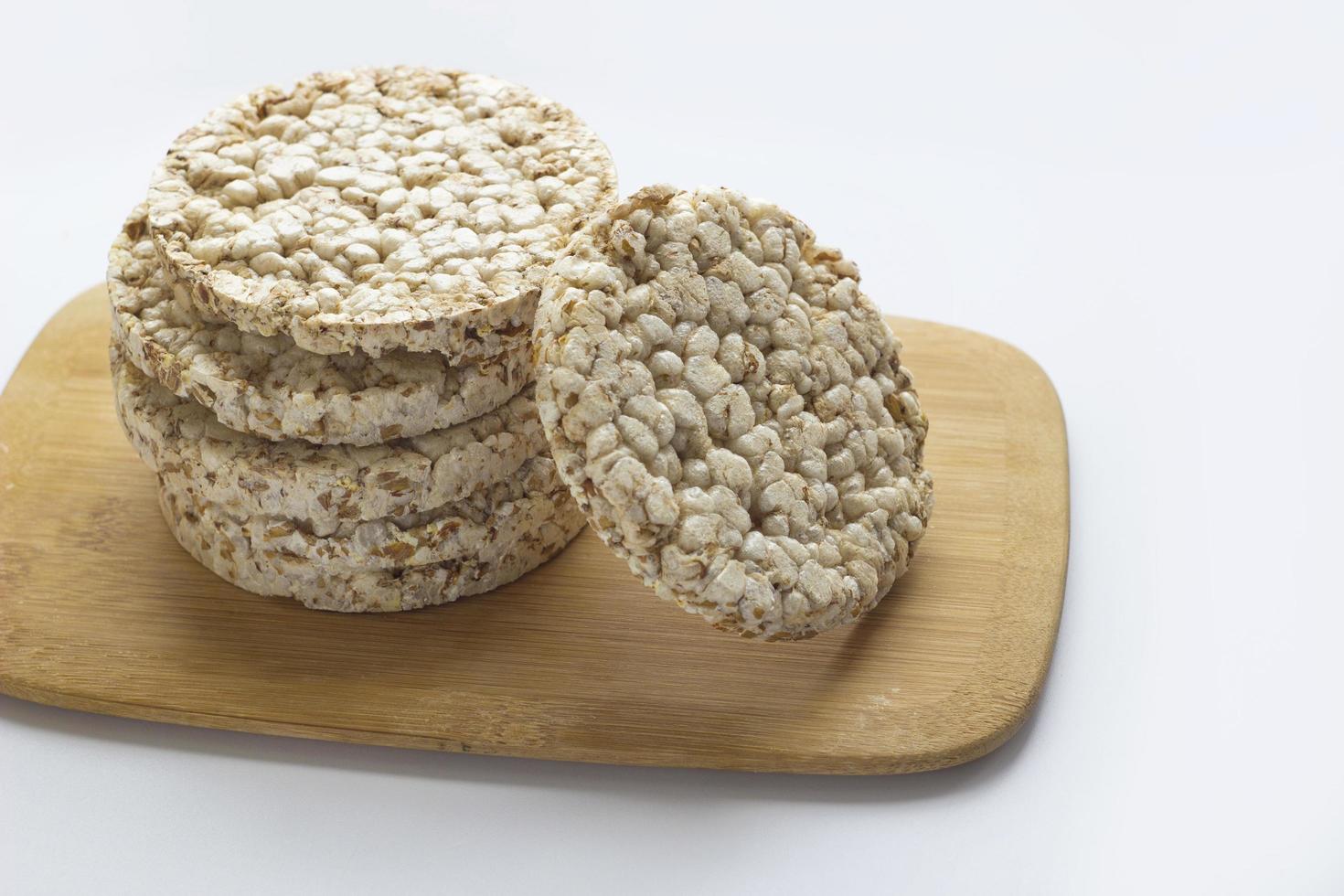 Stack of round rice crispbreads on wooden board. Concept of healthy diet with copy space photo