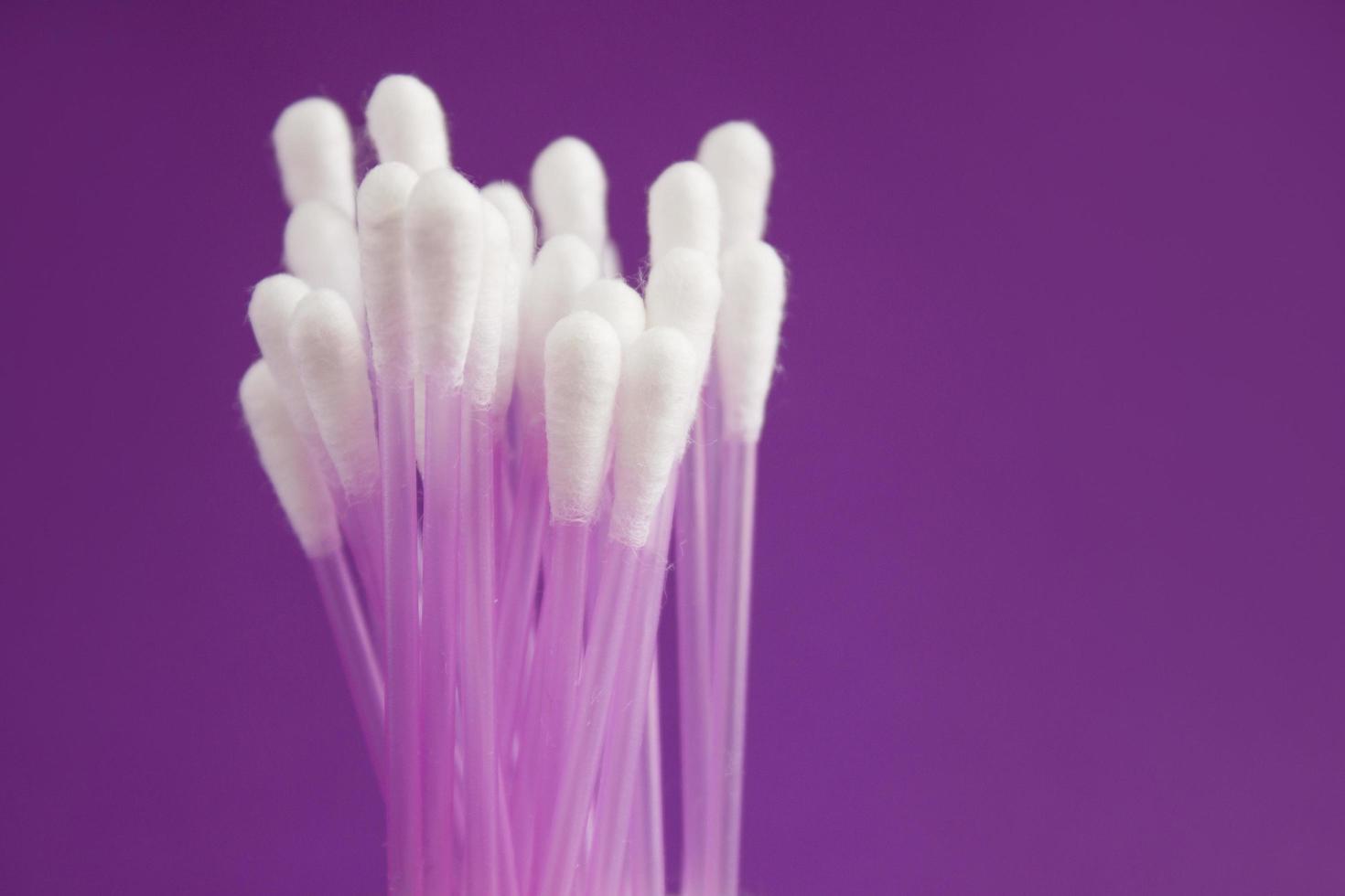 Close up of cotton buds on purple background. Concept with copy space. Medicine and personal hygiene photo