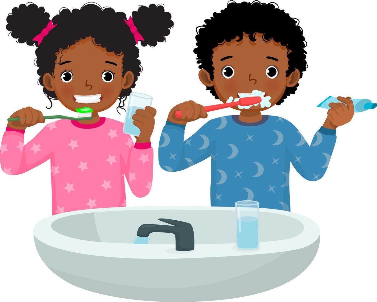 lindo niño y niña africanos en pijama cepillando los dientes con pasta dental sosteniendo un vaso de agua para limpiar la rutina diaria de higiene en el baño vector