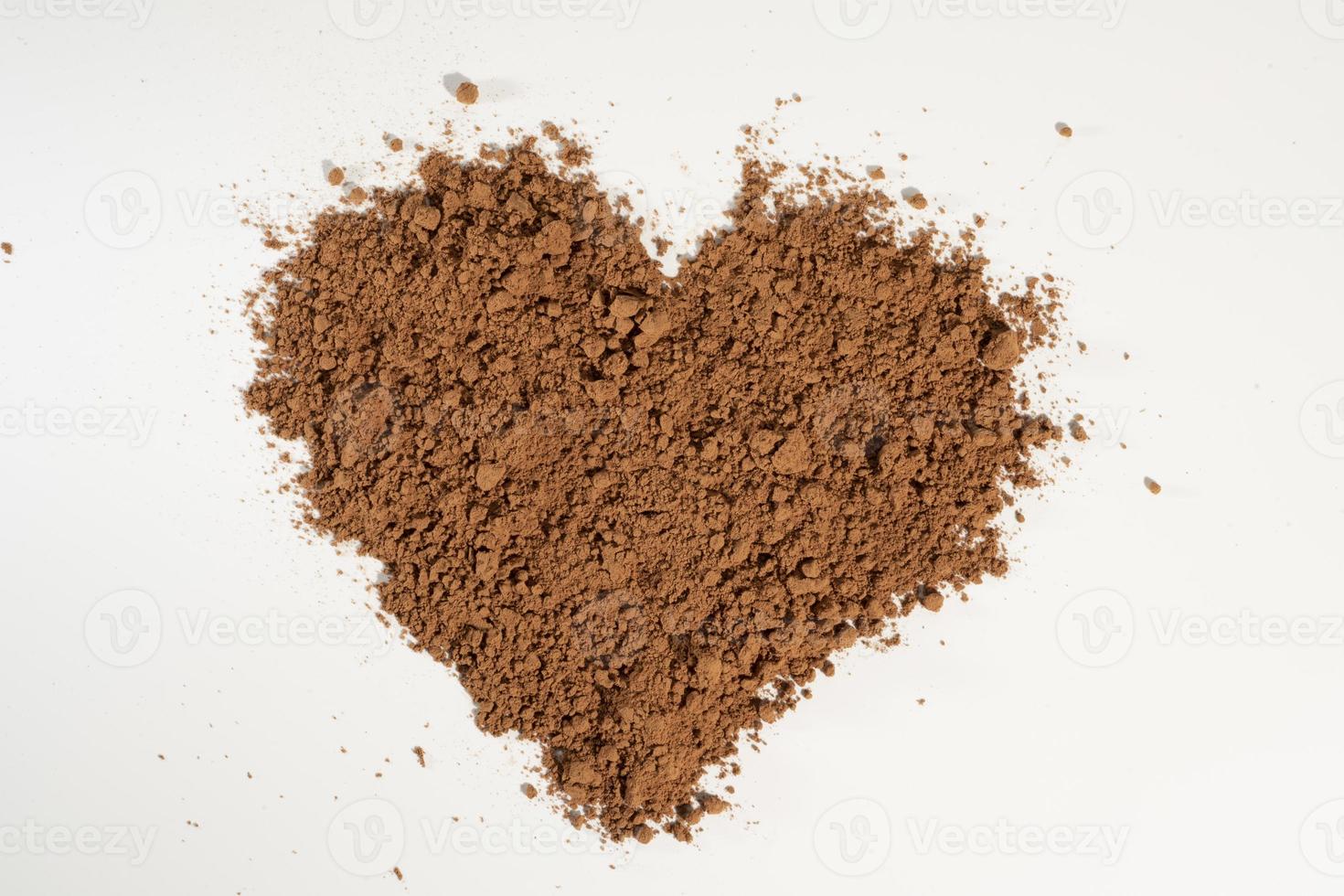 Cacao en polvo vertido en forma de corazón, aislado sobre fondo blanco. foto