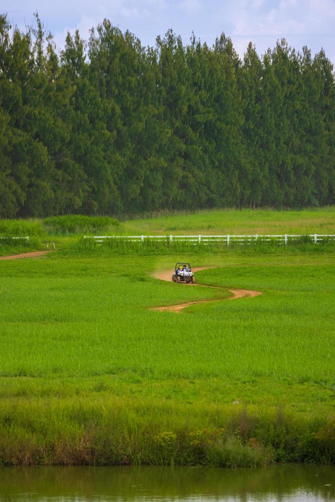 Driving in the green fields behind the mountains with bright blue skies. photo