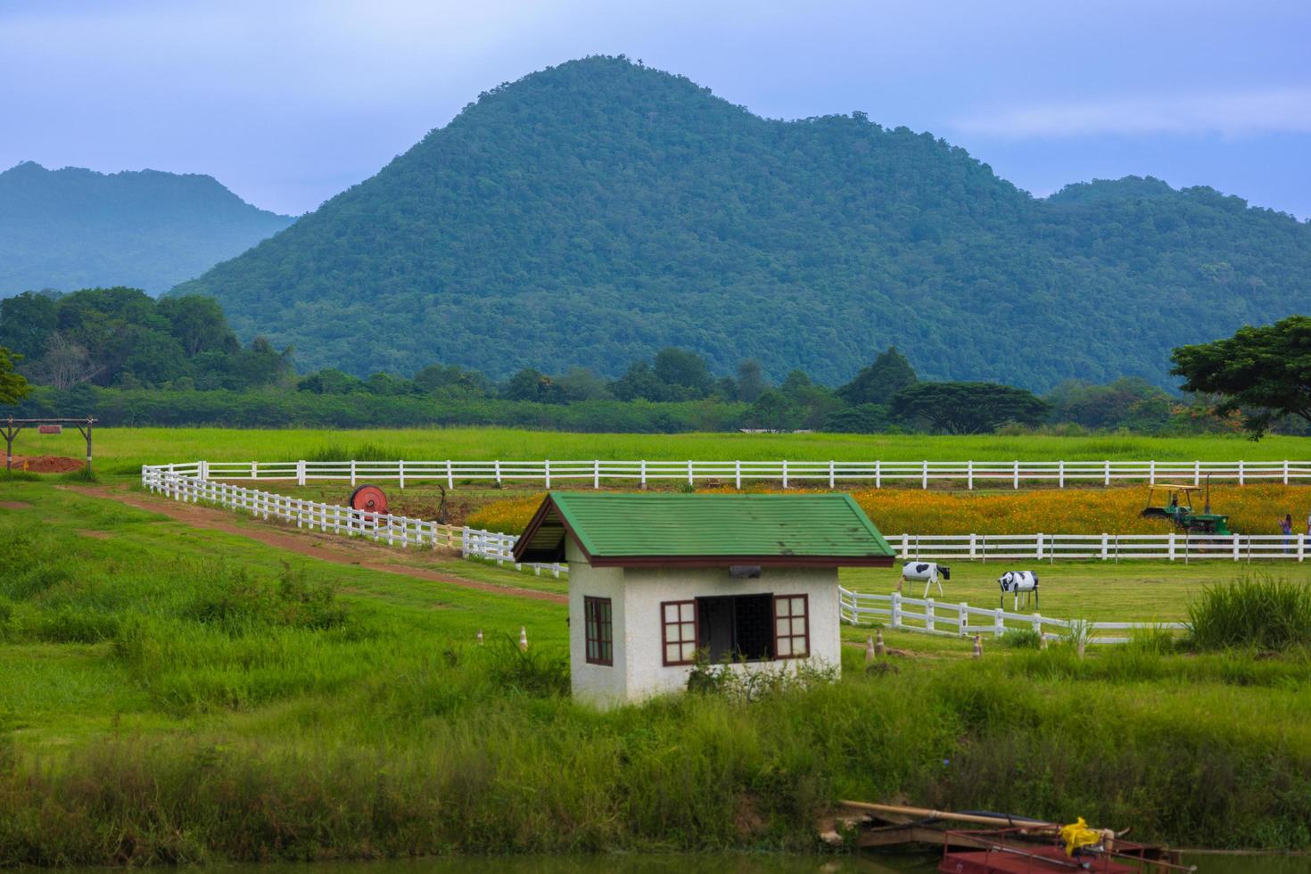 The green ranch behind the mountain has a bright blue sky. photo