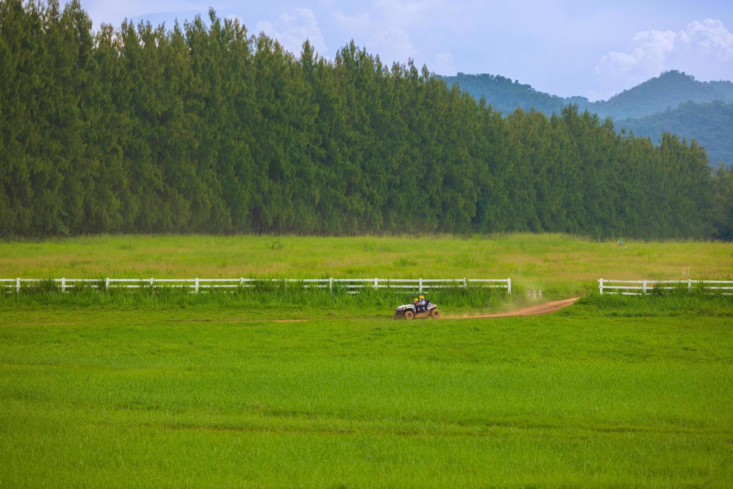 Driving in the green fields behind the mountains with bright blue skies. photo