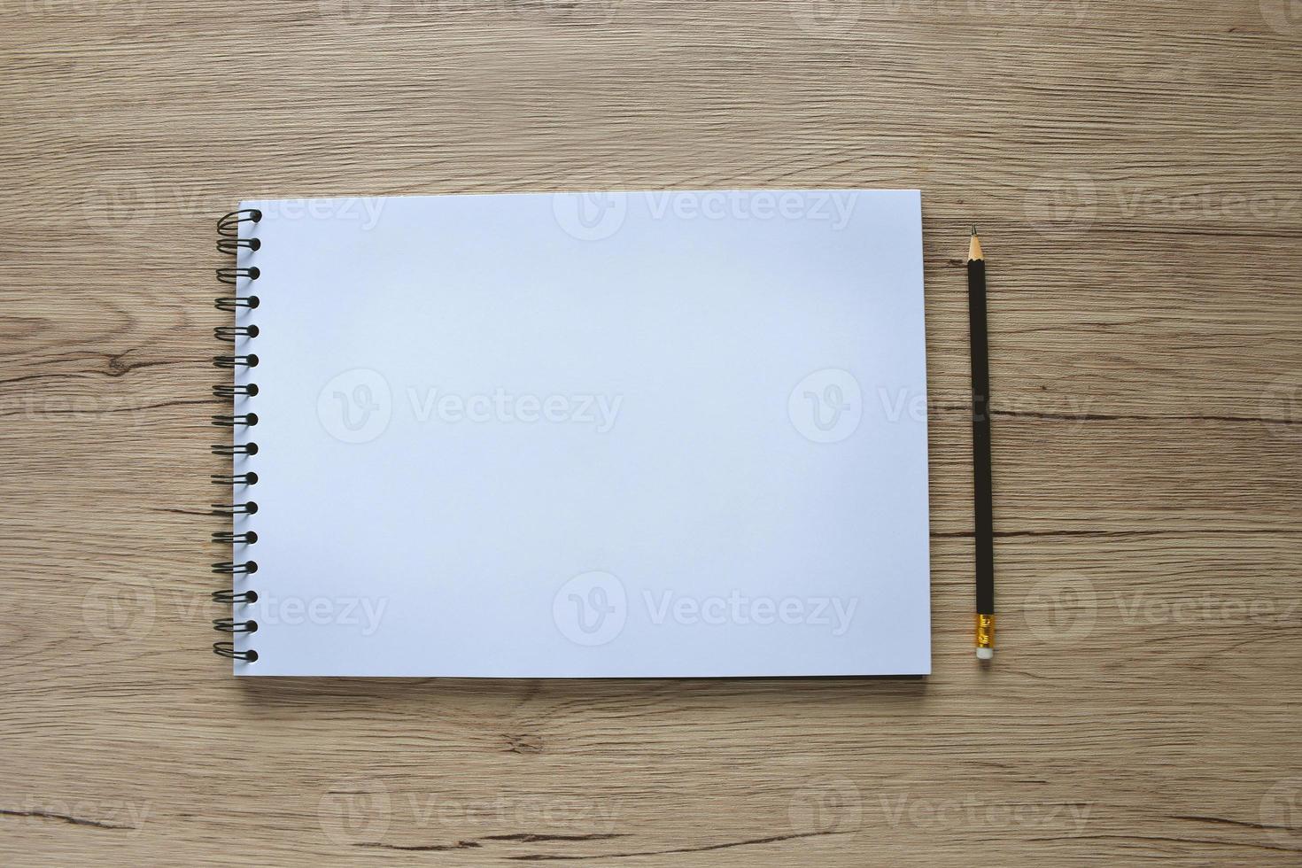 Blank books and pencils placed on a wooden table with copy space. photo