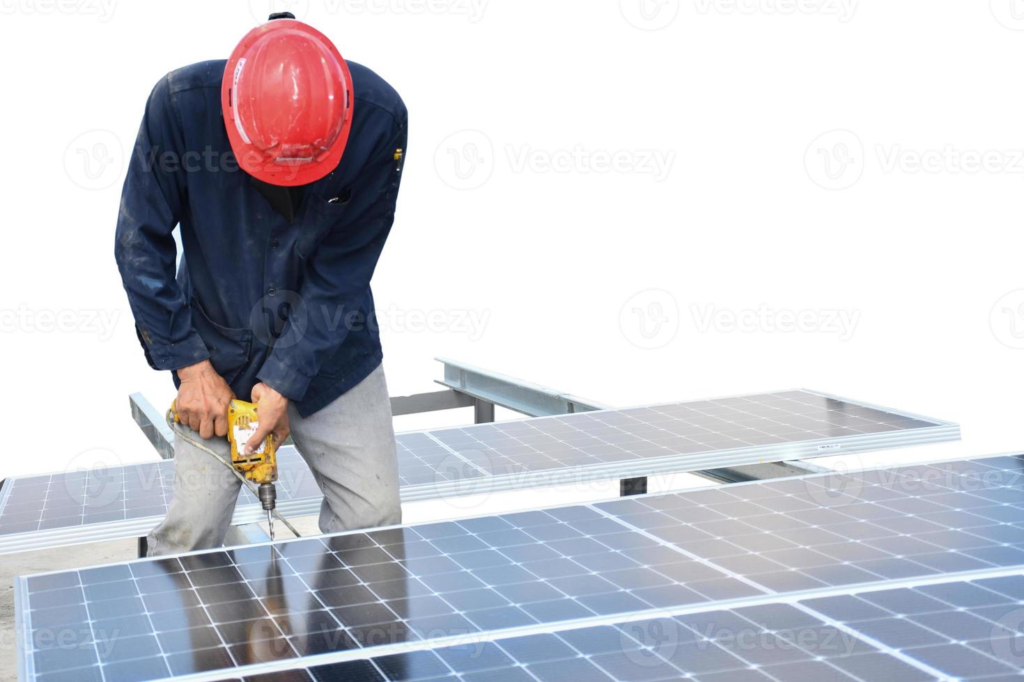 The technician is drilling holes to mount the solar panel Cell with electric drill on top of the roof With clipping path. photo