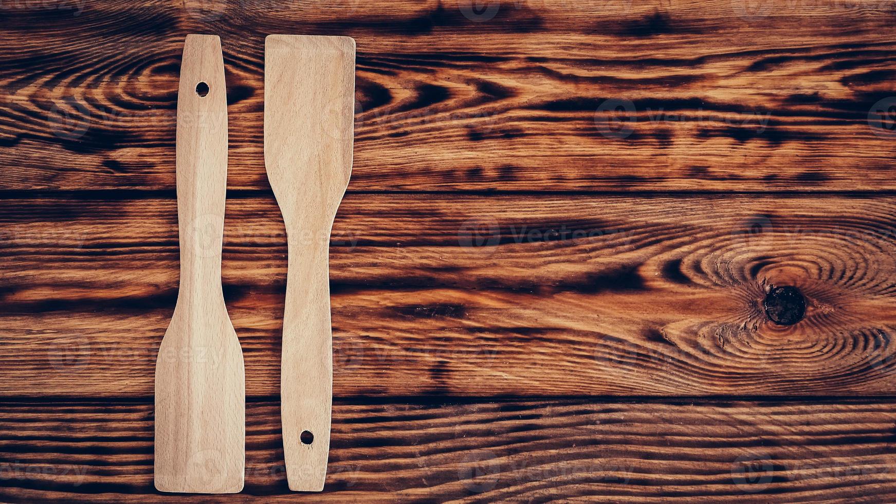 espátulas de cocina de madera sobre fondo de mesa marrón foto