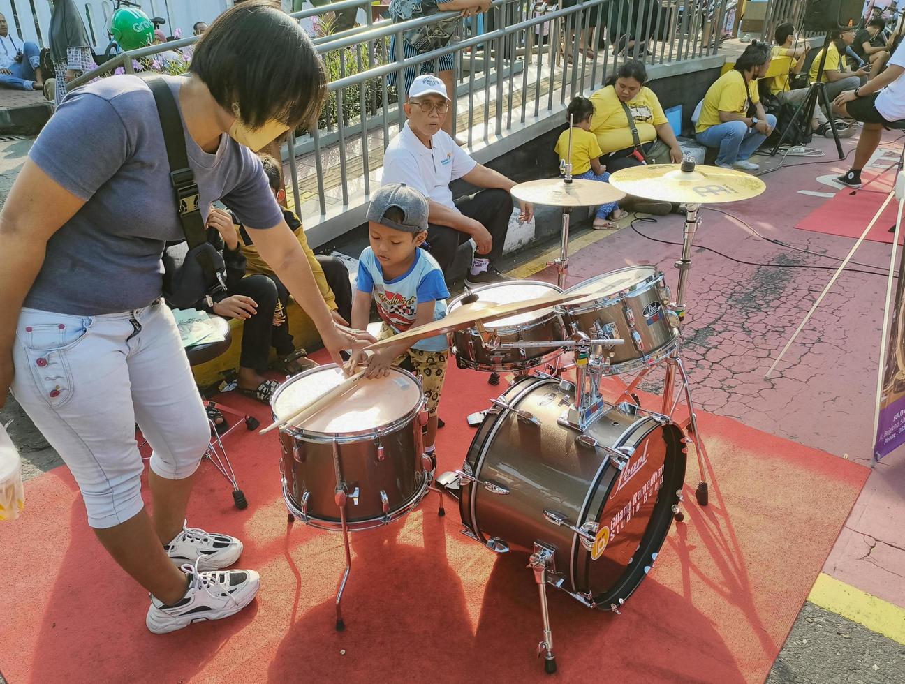 Solo - June 7, 2022 - A mother teaches her son to play drums photo