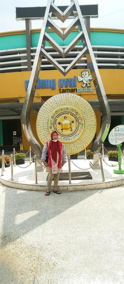 Yogyakarta - June 9, 2022 - Asian woman standing in front of the golden gong monument photo