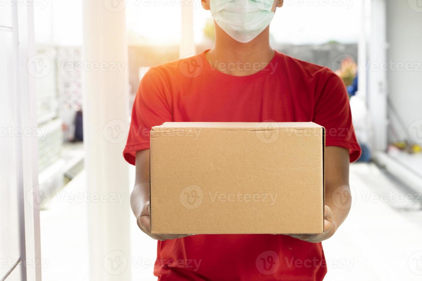 Delivery man with cardboard parcel. Hand holding the delivery box. photo