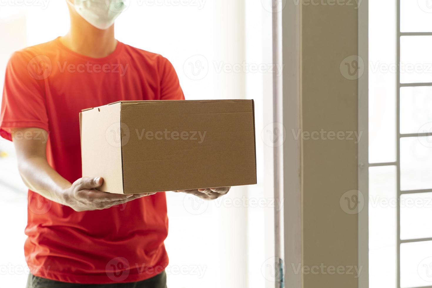 Delivery man with cardboard parcel. Hand holding the delivery box. photo