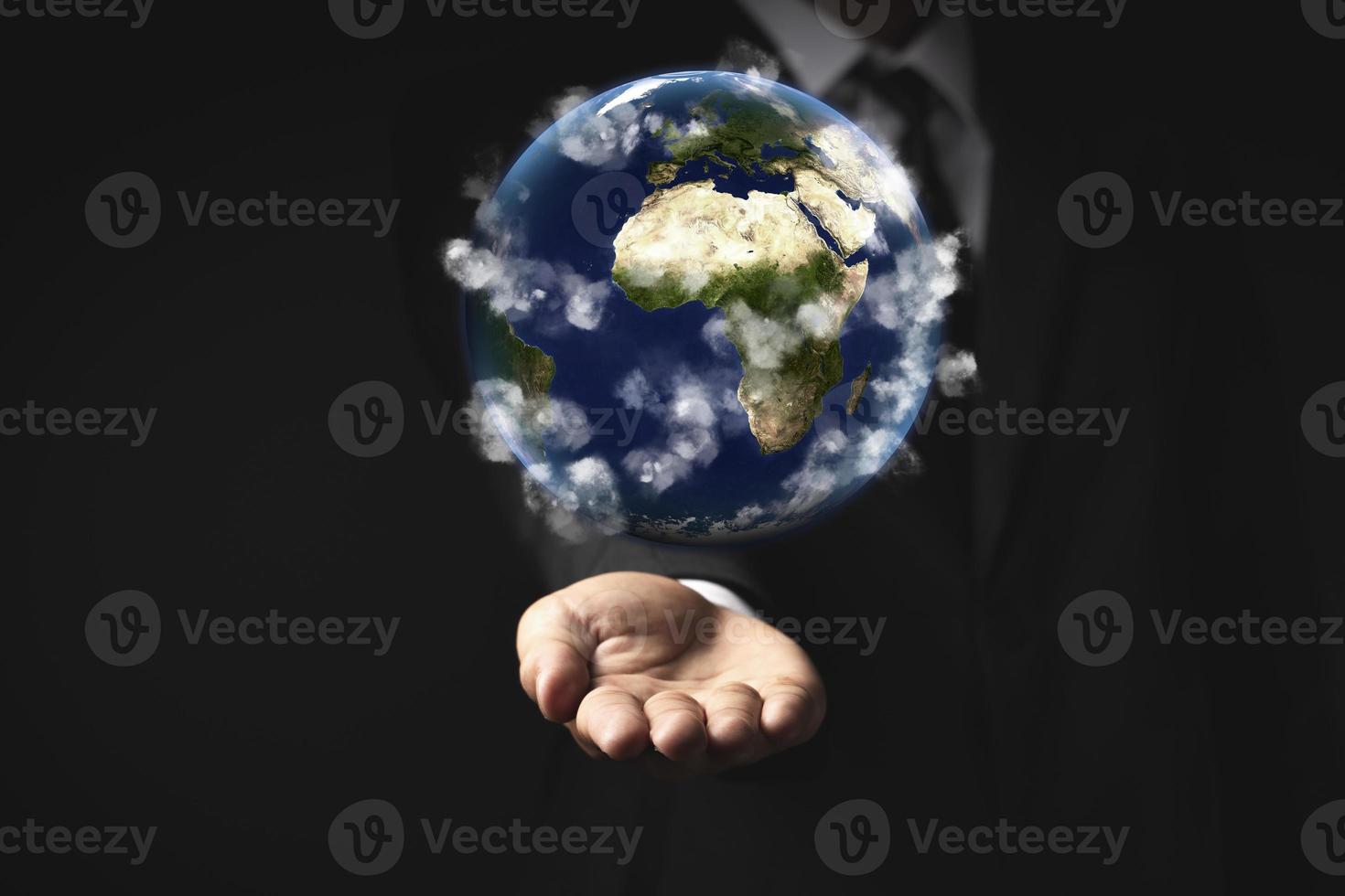 Businessman holding the world in the palm of hands concept for global business, communications, politics or environmental conservation Earth photo