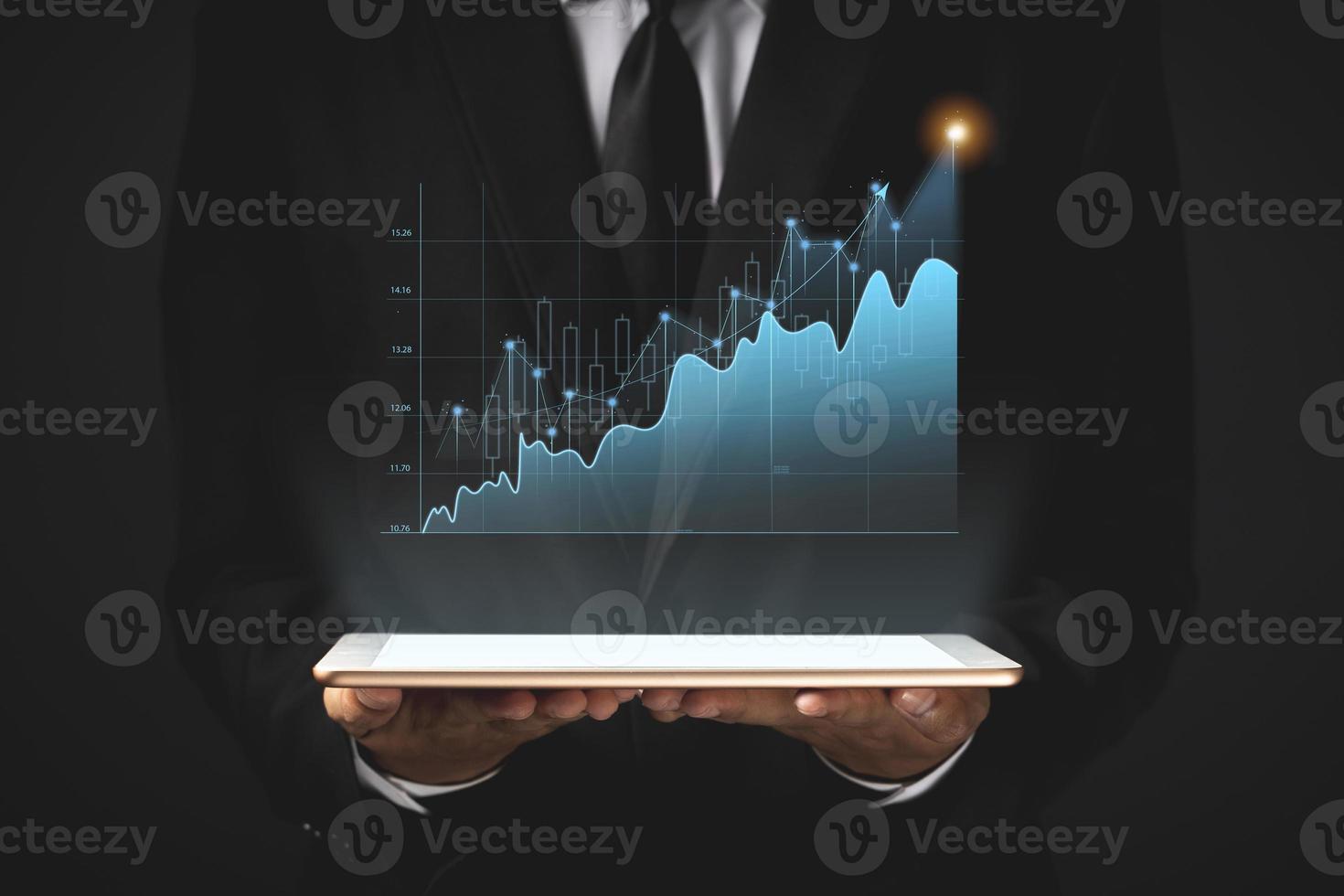 Business man holding tablet and showing holographic graphs and stock market statistics gain profits. photo