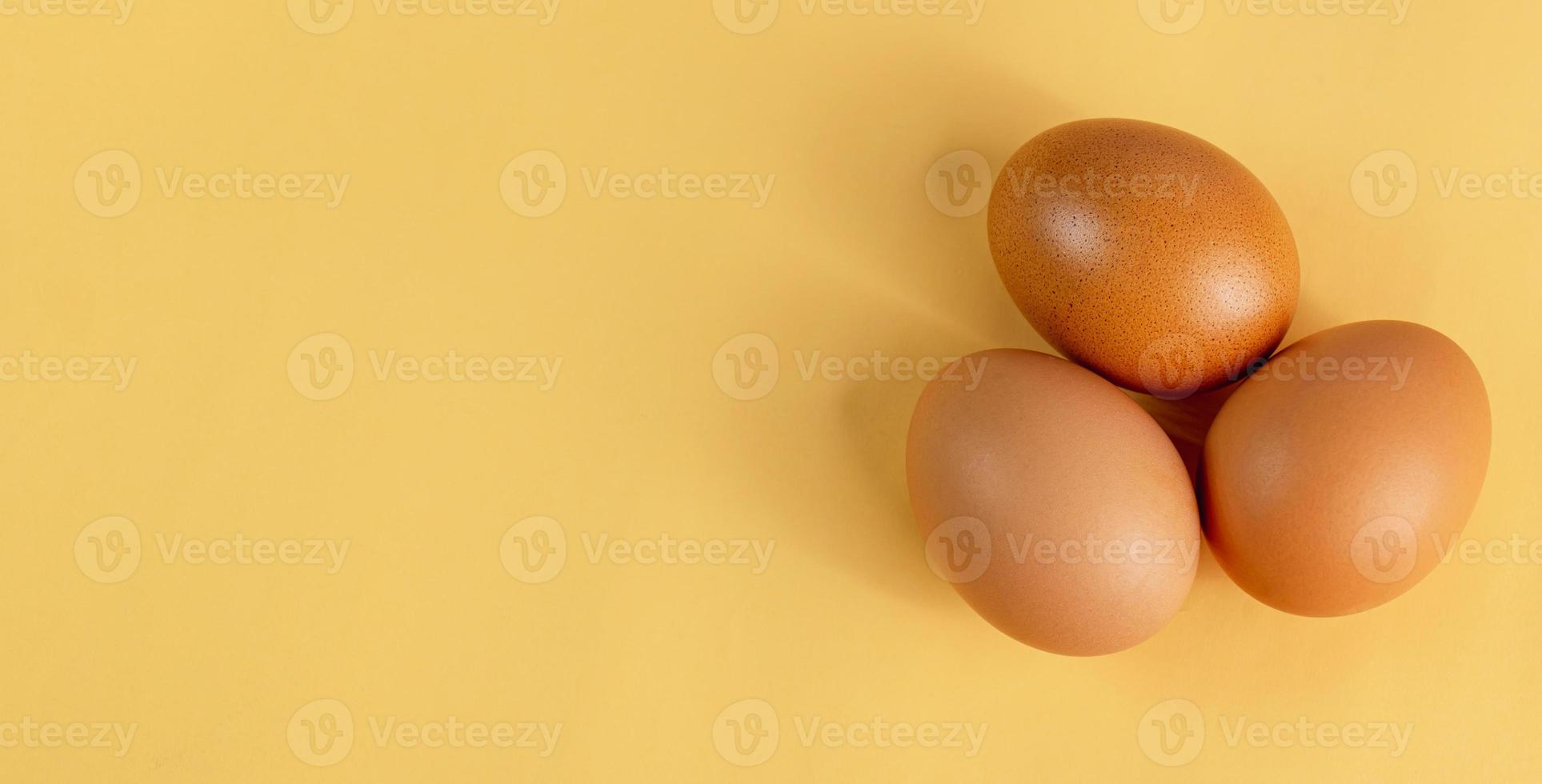 Eggs are laid in groups of three, eggshells with different patterns. Shot in a studio with light and shadows against an eggshell colored background. photo