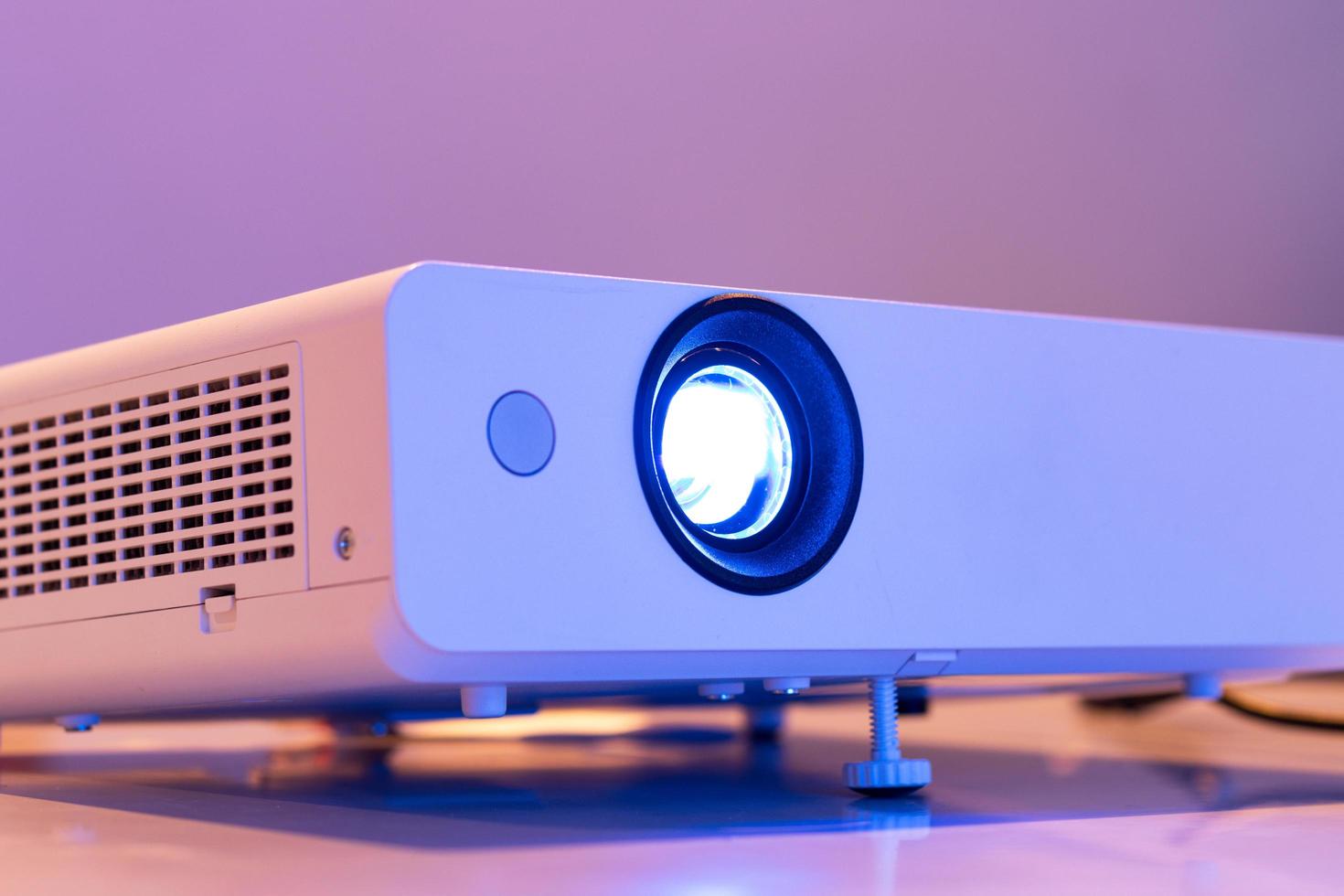 close up the lens of the projector with light for presentation in a dark room presention photo
